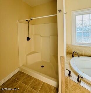 bathroom featuring tile patterned flooring and independent shower and bath