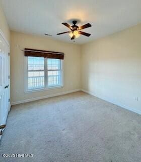 carpeted spare room featuring ceiling fan