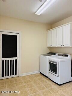 washroom featuring cabinets and washing machine and clothes dryer