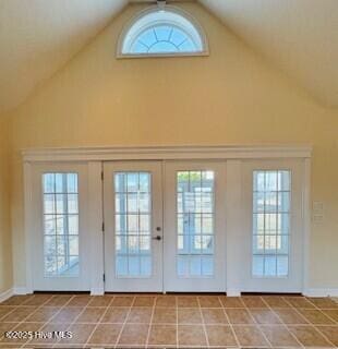 doorway featuring tile patterned floors and high vaulted ceiling