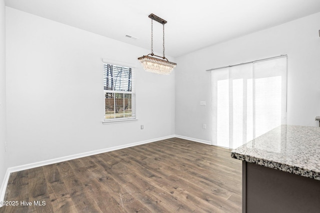 unfurnished dining area with baseboards, visible vents, and dark wood-style flooring