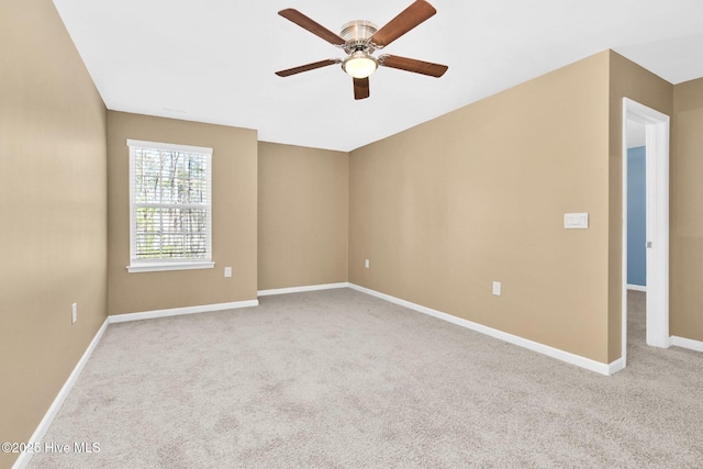 carpeted empty room with ceiling fan and baseboards