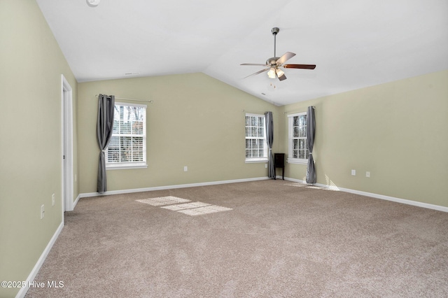 carpeted empty room with a ceiling fan, lofted ceiling, and baseboards