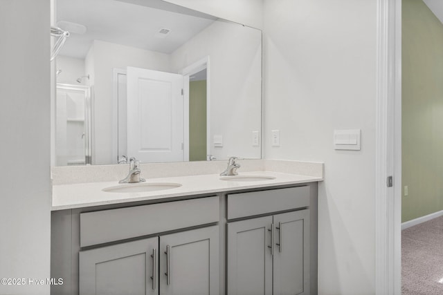 bathroom featuring a sink, baseboards, and double vanity