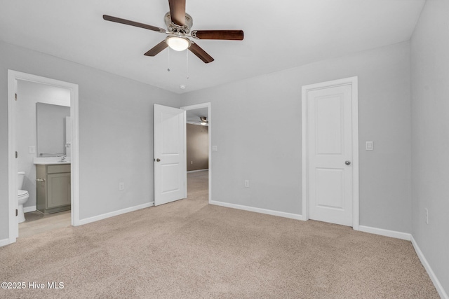 unfurnished bedroom featuring light carpet, ceiling fan, ensuite bath, and baseboards