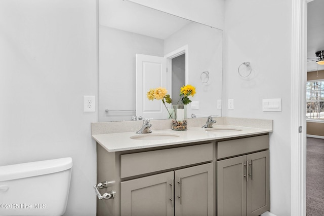 bathroom featuring a sink, toilet, and double vanity