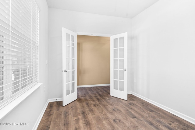 spare room with baseboards, wood finished floors, and french doors