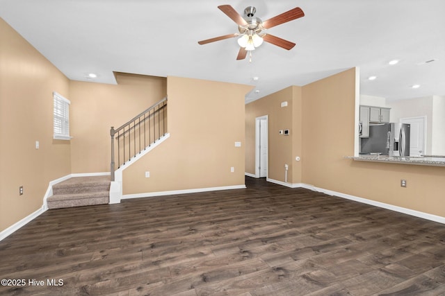 unfurnished living room with dark wood-type flooring, stairway, recessed lighting, and baseboards