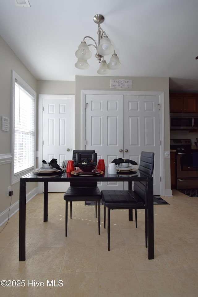 dining room featuring an inviting chandelier and light tile patterned floors