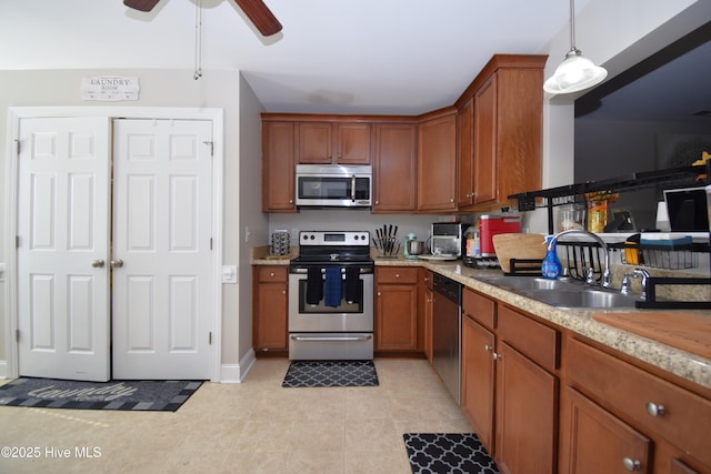 kitchen featuring appliances with stainless steel finishes, decorative light fixtures, sink, light tile patterned floors, and ceiling fan