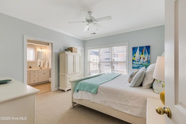 carpeted bedroom with ceiling fan, ornamental molding, and ensuite bathroom