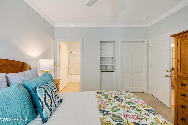 bedroom featuring crown molding, ensuite bath, ceiling fan, light colored carpet, and a closet