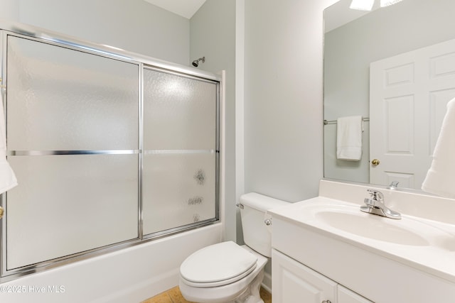 full bathroom featuring vanity, enclosed tub / shower combo, and toilet