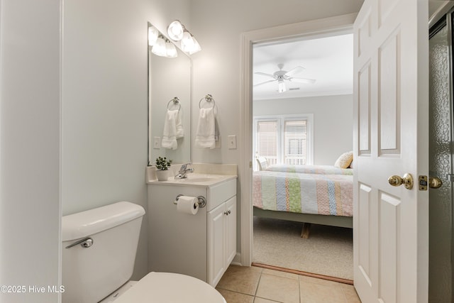 bathroom featuring ceiling fan, vanity, ornamental molding, tile patterned floors, and toilet