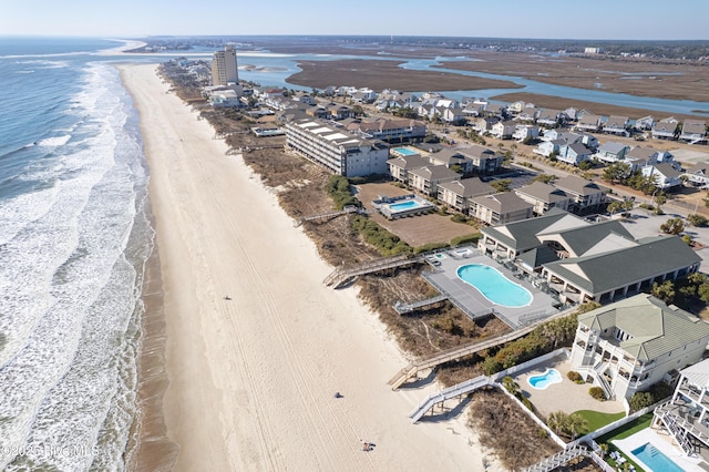 birds eye view of property featuring a beach view and a water view