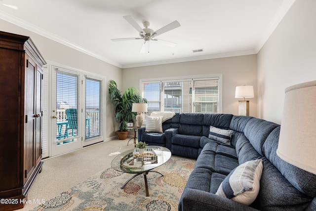 carpeted living room with crown molding and ceiling fan