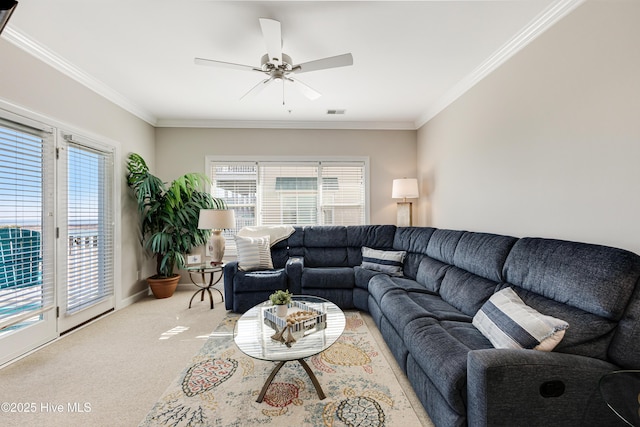 carpeted living room featuring ceiling fan, ornamental molding, and plenty of natural light