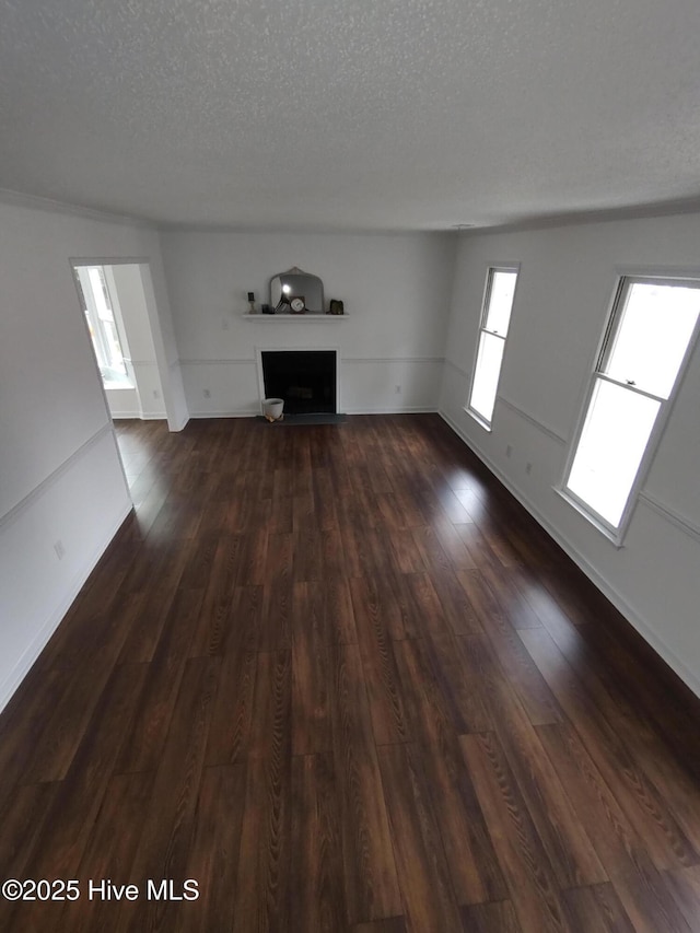 unfurnished living room with dark hardwood / wood-style floors and a textured ceiling