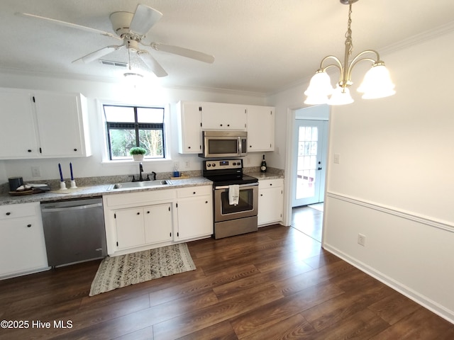 kitchen with dark hardwood / wood-style floors, pendant lighting, sink, white cabinets, and stainless steel appliances