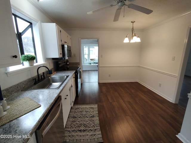 kitchen featuring sink, white cabinets, hanging light fixtures, stainless steel appliances, and dark wood-type flooring