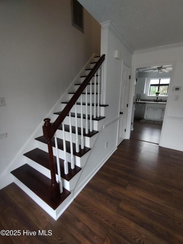 stairs featuring crown molding, sink, and hardwood / wood-style flooring