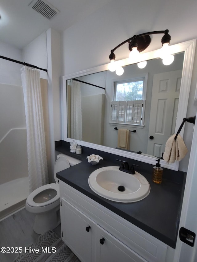 bathroom featuring vanity, curtained shower, and toilet