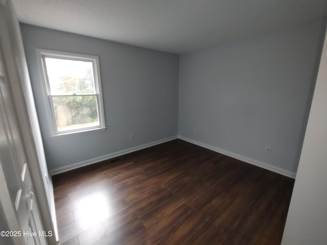 unfurnished room featuring dark wood-type flooring