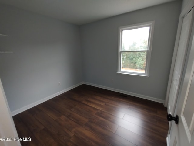 spare room with dark hardwood / wood-style flooring