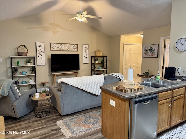 kitchen with vaulted ceiling, sink, dark hardwood / wood-style flooring, stainless steel dishwasher, and ceiling fan