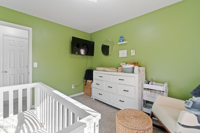 carpeted bedroom featuring a crib and a textured ceiling