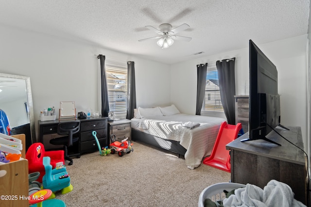 bedroom with carpet flooring, multiple windows, and a textured ceiling