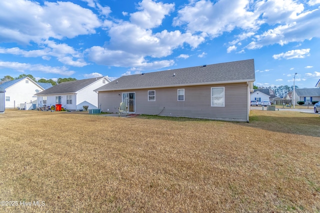 back of property with a yard and central air condition unit