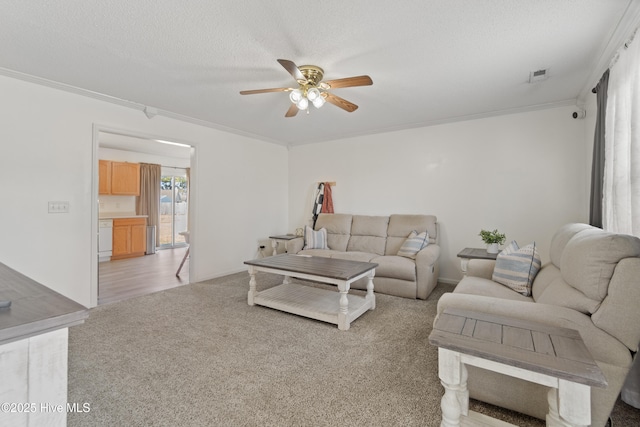 living room with crown molding, light colored carpet, ceiling fan, and a textured ceiling