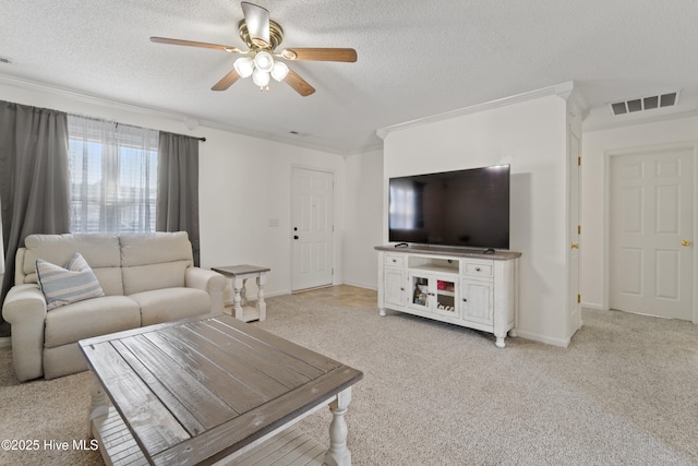 carpeted living room featuring crown molding, ceiling fan, and a textured ceiling