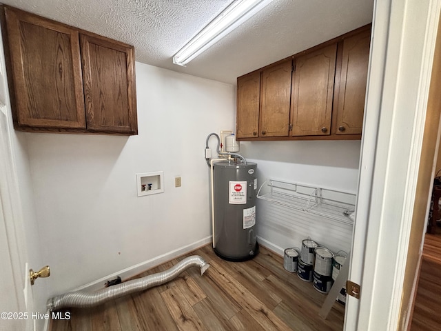 laundry area featuring water heater, wood-type flooring, a textured ceiling, and cabinets