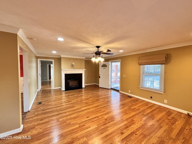 unfurnished living room with crown molding, ceiling fan, and light wood-type flooring