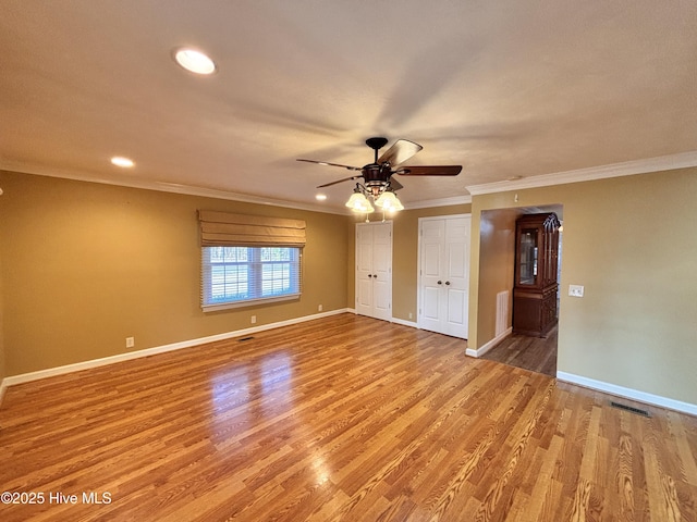 empty room featuring crown molding, ceiling fan, and wood-type flooring