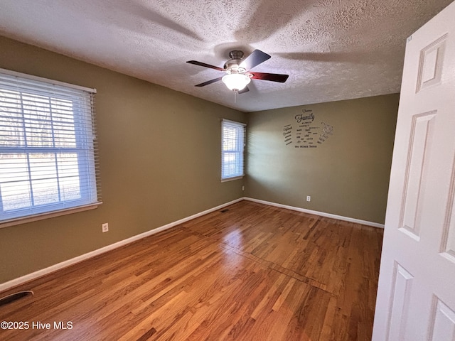 spare room featuring ceiling fan, hardwood / wood-style floors, and a textured ceiling