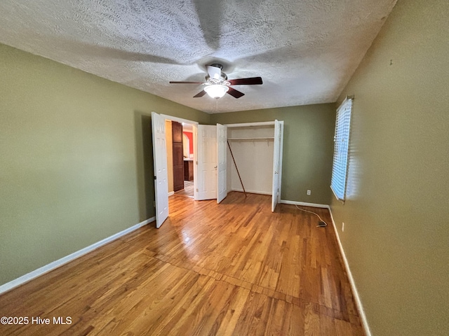 unfurnished bedroom featuring ceiling fan, light hardwood / wood-style flooring, a closet, and a textured ceiling