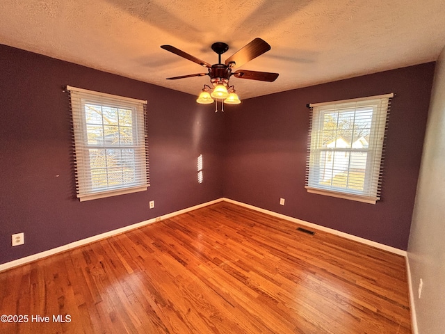 empty room featuring ceiling fan, light hardwood / wood-style flooring, and a textured ceiling