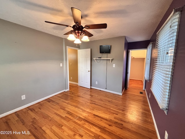 unfurnished bedroom with ceiling fan, light hardwood / wood-style floors, and a textured ceiling