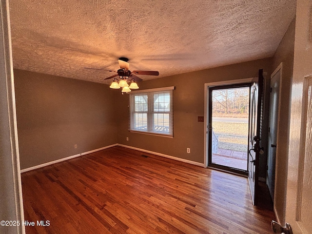 unfurnished room with ceiling fan, wood-type flooring, and a textured ceiling