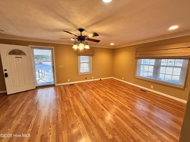 interior space featuring hardwood / wood-style flooring, ornamental molding, ceiling fan, and a textured ceiling