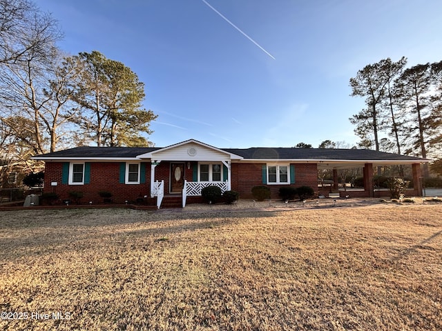 ranch-style home featuring a carport, a porch, and a front lawn