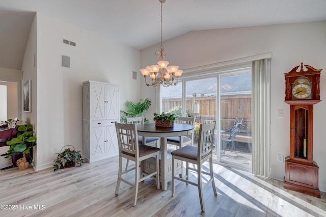 dining space with high vaulted ceiling, light hardwood / wood-style floors, and a notable chandelier