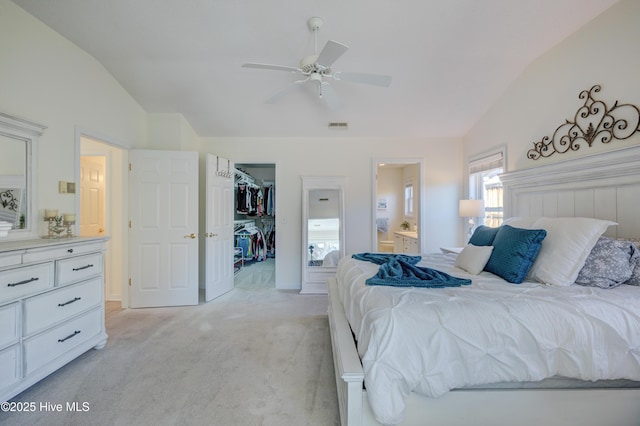 carpeted bedroom with vaulted ceiling, a spacious closet, ensuite bathroom, and a closet