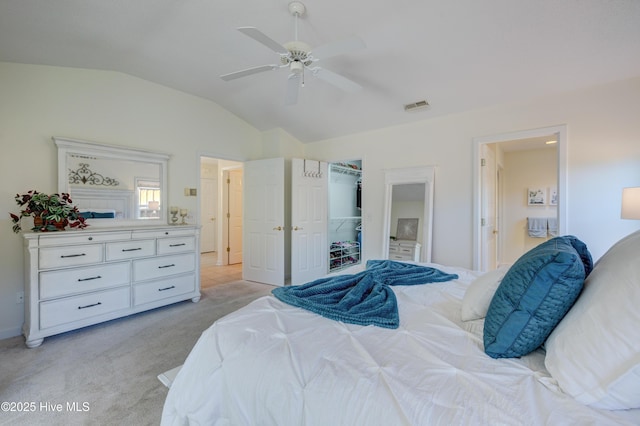 carpeted bedroom featuring vaulted ceiling, connected bathroom, and ceiling fan