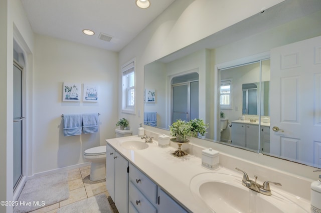 bathroom featuring vanity, toilet, a healthy amount of sunlight, and walk in shower