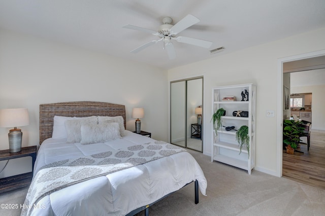 carpeted bedroom with ceiling fan and a closet