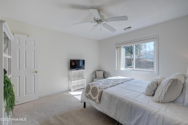 bedroom featuring ceiling fan, carpet flooring, and a textured ceiling